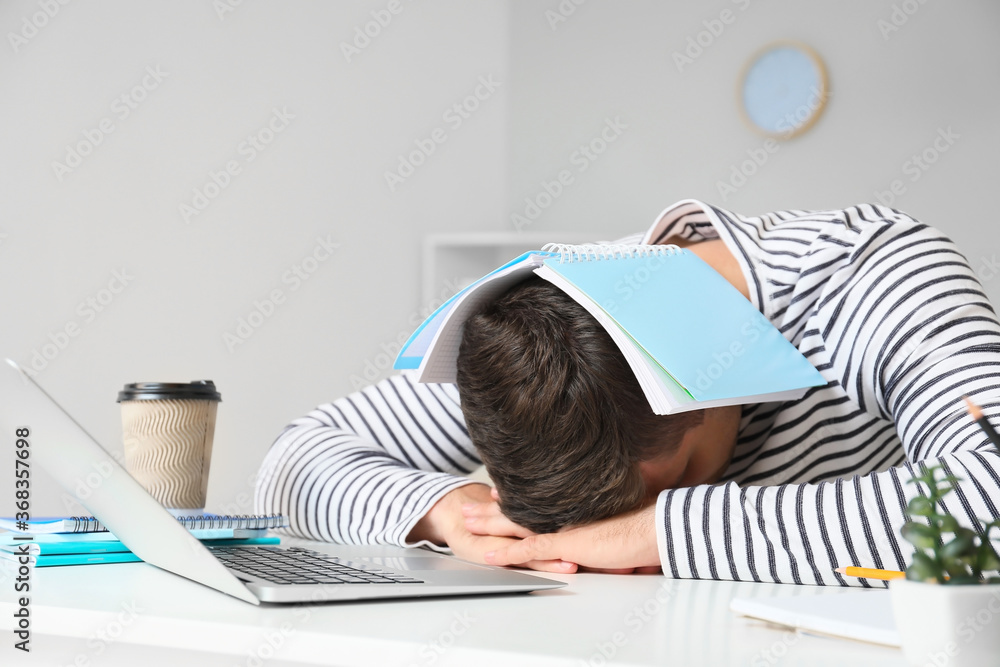 Tired student sleeping at table