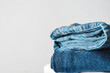 © Pixel-Shot - Stack of jeans pants on light background