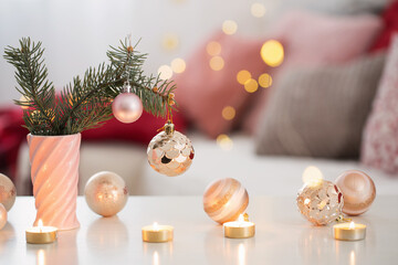 Christmas decorations with burning candles in pink and gold colo