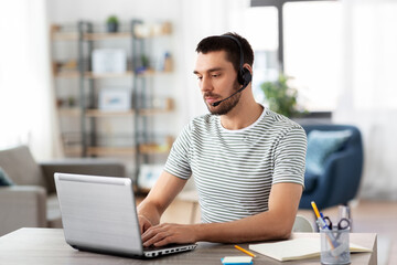 Poster - remote job, technology and people concept - man with headset and laptop computer having video conference at home office