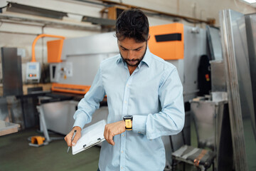 Middle age businessman doing quality control checking at industry production. Factory for industrial production of electric housings and surge arresters.