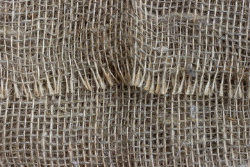 The structure of the threads of a natural burlap fabric close up.