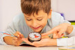 Boy with autism spectrum disorder during ABA therapy look at lesson timer in teachers hands understanding time concept