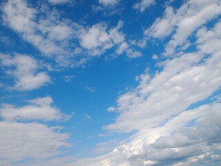 Texture blue sky with white fluffy clouds on a sunny day.