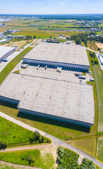 Sticker - Aerial view of goods warehouse. Logistics center in industrial city zone from above. Aerial view of trucks loading at logistic center stock photo