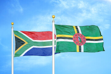 South Africa and Dominica two flags on flagpoles and blue sky