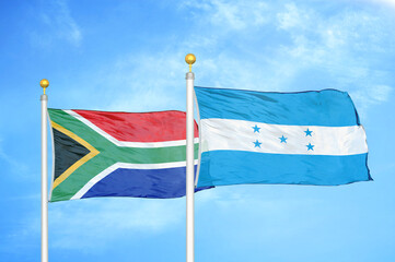 South Africa and Honduras two flags on flagpoles and blue sky