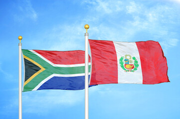 south africa and peru two flags on flagpoles and blue sky