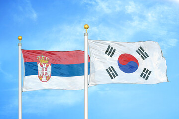 Serbia and South Korea two flags on flagpoles and blue sky