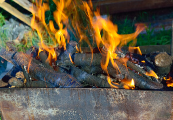 close-up - the fire flares up in the grill with a bright orange flame