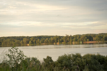 the river overlooking the green forest at sunset