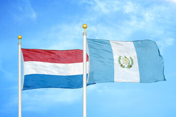 Wall Mural - Netherlands and Guatemala two flags on flagpoles and blue sky