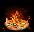 © New Africa - Hot tasty pizza with fire flames on dark background. Image for menu or poster