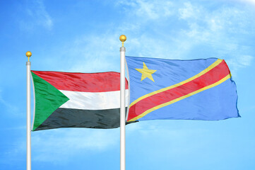 Sudan and Congo Democratic Republic two flags on flagpoles and blue sky