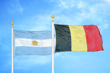 Argentina and Belgium two flags on flagpoles and blue sky