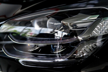 Wall Mural - Close-up image of headlights of black premium car