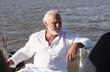 © YamilaG - Hombre de tercera edad sentado en un barco, contemplando la vista.