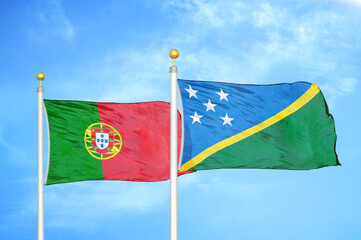 Portugal and Solomon Islands two flags on flagpoles and blue sky