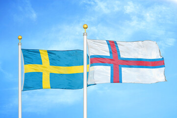 Sweden and Faroe Islands two flags on flagpoles and blue sky