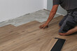 © leomalsam - The worker installing new vinyl tile floor
