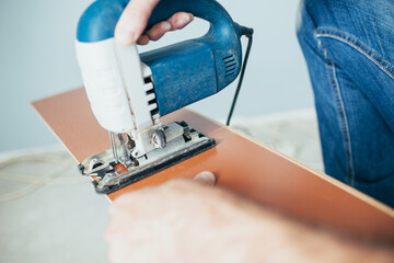 Wall Mural - Sawing laminate boards with a jigsaw - neat work on laying the laminate - self-repair of the floor in the house