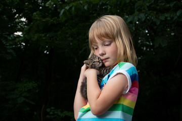 Wall Mural - Young girl holding pet tabby kitten