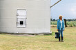 © Creative Flame - Woman standing near corn and grain storage house