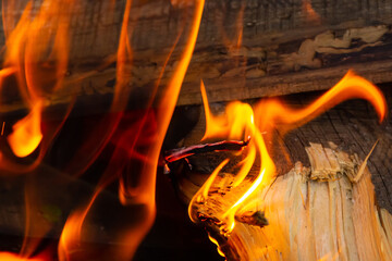 fire bright tongues of flame among firewood close-up base background creation of a cosiness