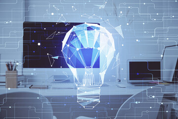 Computer on desktop in office with bulb icon hologram. Double exposure. Concept of idea.