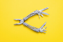 Steel Multi Tool On The Yellow Flat Lay Background.