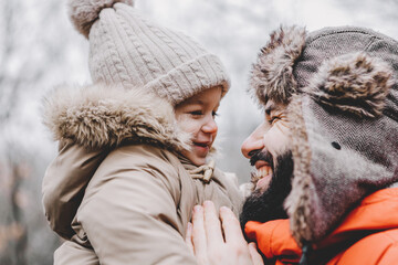 Canvas Print - Handsome young dad and his little sweet daughter have fun outdoors in winter. Happy family spending time together. Family concept.