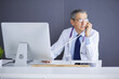 © lenets_tan - Portrait of senior doctor sitting in medical office