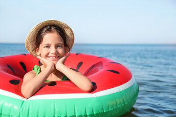 Sticker - Cute little child with inflatable ring in sea on sunny day. Beach holiday