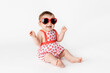 © Lisa Tichané - Cute smiling baby with heart-shaped glasses and strawberry outfit