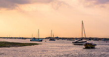 A View Of Boats Moored At Blakeney Point, Norfolk At Low Tide Just Before Sunset
