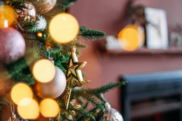 Wall Mural - Decorated Christmas tree in gold and purple toys with lights bokeh in living room textured background