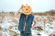 man in a denim jacket over his naked body with a Halloween pumpkin on his head