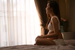 © etemwanich - a beautiful woman pregnant in sit on bed beside windows smiley happy and relax in bedroom her