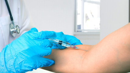 Wall Mural - Doctor makes vaccination in the shoulder of female patient in a hospital. Vaccine or flu shot in injection needle.