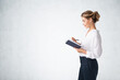 © ImageFlow - Businesswoman with notebook, side view