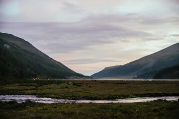 Wall Mural - amazing mountain landscape of sunset with pink glowing water in small river. atmospheric highland sc