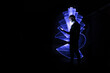 © Bruno - Silhouette of a man using a smartphone. Abstract shape at lightpainting with a light saber. Face illuminated by screen.