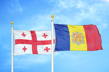 Georgia and Andorra two flags on flagpoles and blue sky