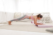 © Gennady Danilkin - young sports girl in sportswear is doing yoga and stretching at home in a bright room.