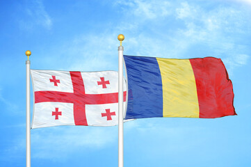 Georgia and Romania two flags on flagpoles and blue sky