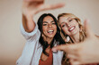 © Look! - Blithesome blonde girl spending free time with best friend. Wonderful european sisters funny posing in studio.