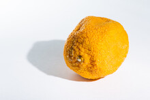 Aging Concept: Shriveled Orange With Shadow On White Background