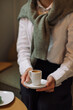 © Nina - Woman in white  blouse and black trousers holding cup of coffee on the business meeting.