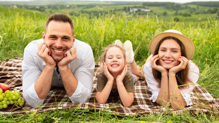 Wall Mural - Happy young family spending time together on a picnic