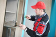 © Kadmy - Furniture assembling. Professional worker installing wardrobe handle at living room of new house.